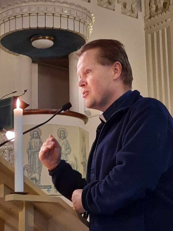 Jukka Kääriäinen puhujakorokkeella kirkossa.