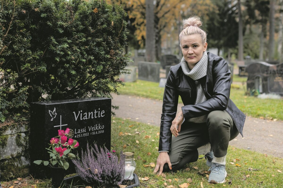 Nainen vierailemassa isänsä haudalla.