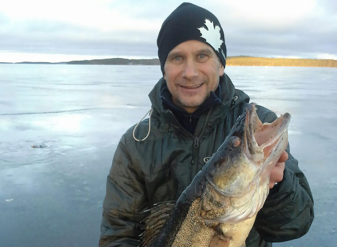 Markku Autio pitelee verkolla saamaansa isoa kuhaa järven jäällä.
