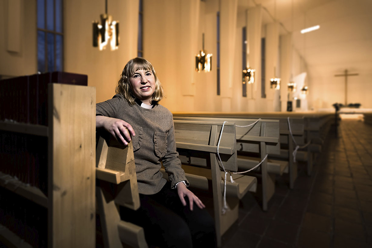 Seurakuntapastori Anna Merivirta istuu Lakeuden Ristin -kirkon penkillä.