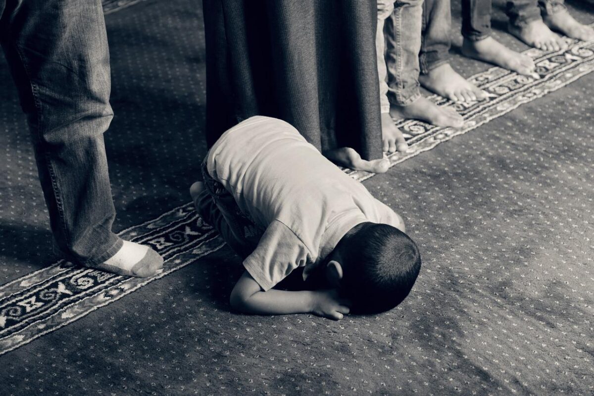 Lapsi rukoilee maahan kumartuneena