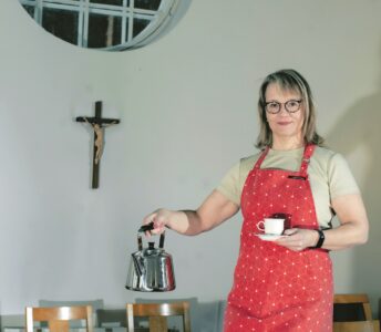 Nainen kahvipannu kädessä.