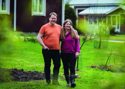 Kalle Hiltunen ja Karoliina Virkamäki nojaavat toisiinsa kesäisessä kotipihassaan.