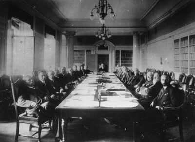 Kuva vuodelta 1937 kansainvälisen Life and Work konferenssista: ihmisiä pöydän ympärillä