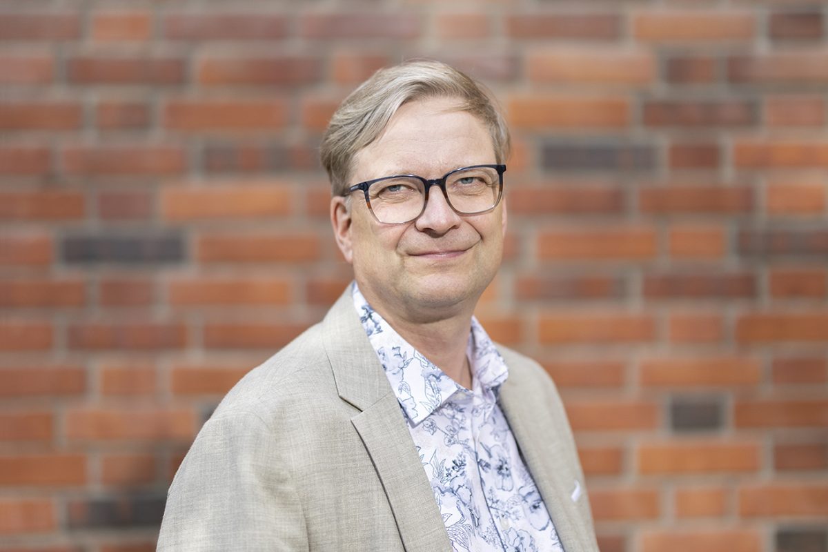 Jyväskylän yliopiston uusi rehtori Jari Ojala yliopiston tiiliseinän edessä.