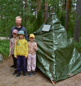 Isä ja lapset leirillä.