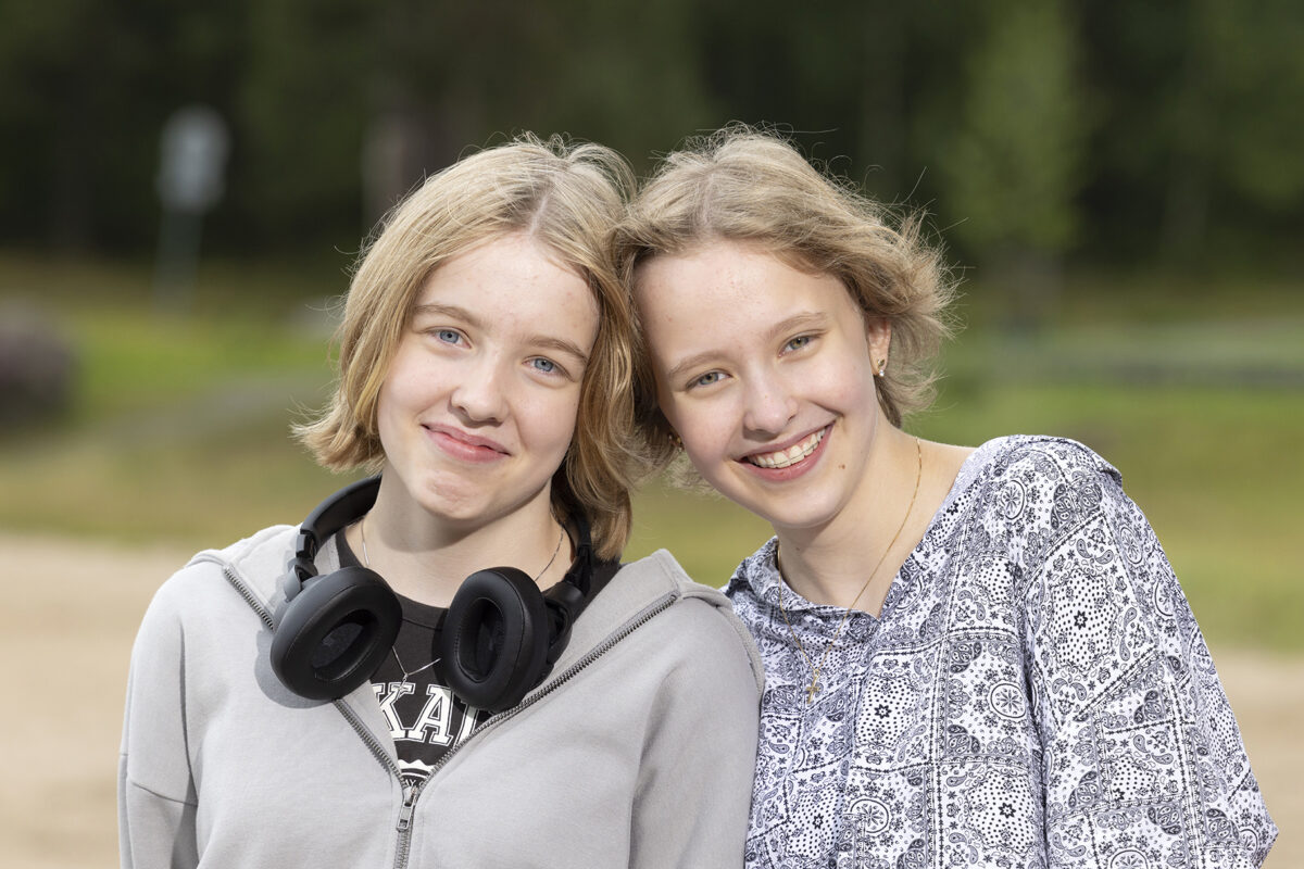 Sisarukset Julia ja Jenna Alakoski päät vastakkain Tuomiojärven rannalla.