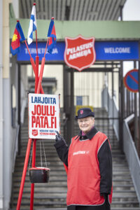 Seija Kortelainen Pelastusarmeijan univormussaan seisoo joulupadan äärellä.