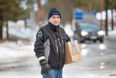 Harri Rautio kylän raitilla postipaketti kainalossaan.
