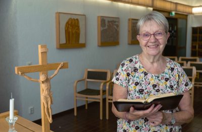 Riitta Niemi Kuusankosken seurakuntakeskuksen kappelissa avoin raamattu käsissään.