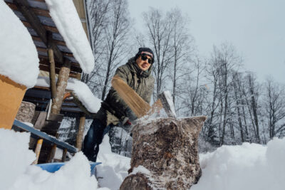 Timo Suutarinen hakkaa halkoja ulkona talvella.