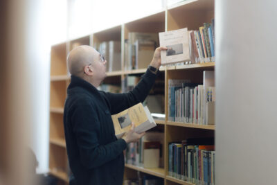 Timo Suutarinen nostelee kirjoja kirjaston hyllyiltä.
